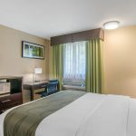 Queen Bed across from Dresser and TV at Quality Inn & Suites Albany