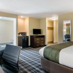 King Bed End with Chair, Desk, Dresser, and TV at Quality Inn & Suites Albany